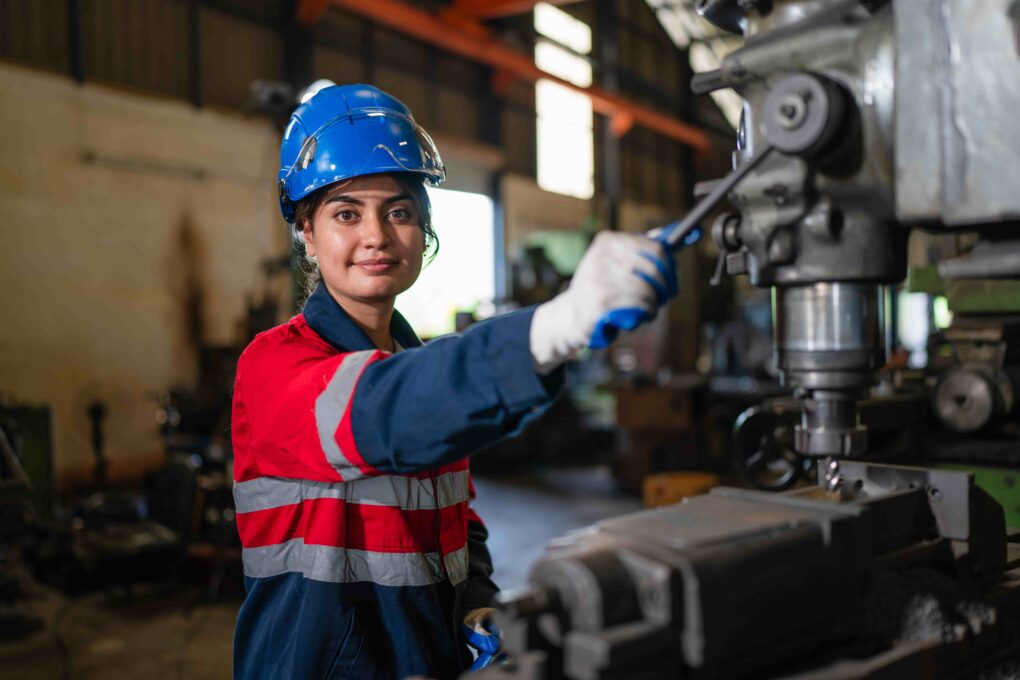 machine shop worker operating drill press machine